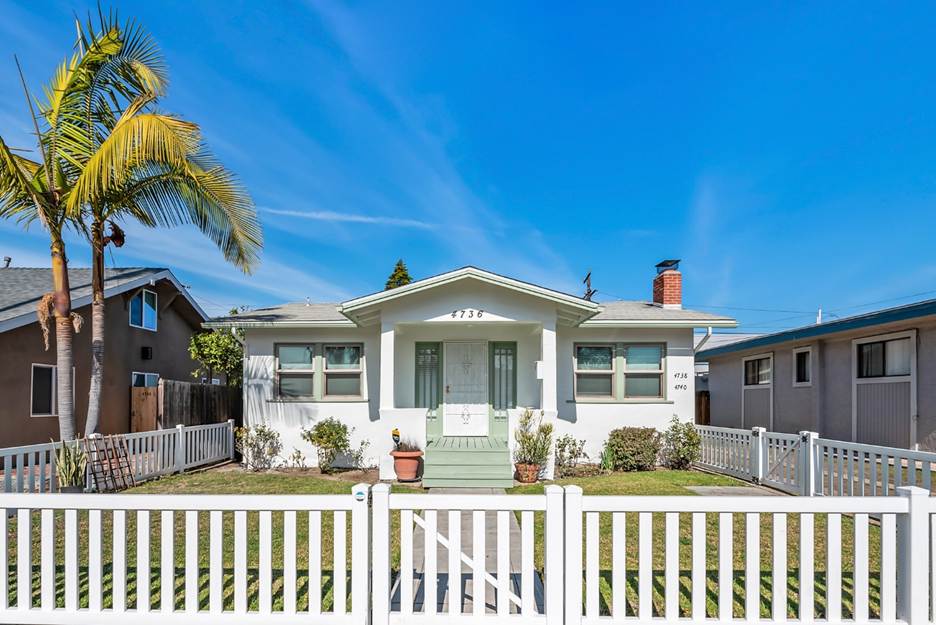 A white house with a white fence and palm trees

AI-generated content may be incorrect.